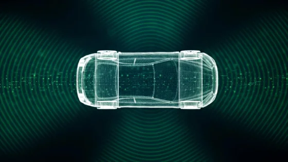 Digital wireframe illustration of a car viewed from above, surrounded by green waves or radar signals on a dark background, suggesting concepts of autonomous driving, vehicle technology, or sensors.