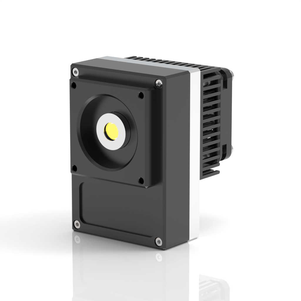 A compact, rectangular industrial device with a circular lens or sensor in the center and a finned heat sink on the back, standing on a reflective surface against a white background.