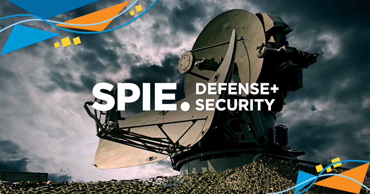 A large satellite dish points toward a cloudy sky, with the text SPIE. Defense + Security in bold white letters over it. Blue and orange graphic accents frame the corners of the image.