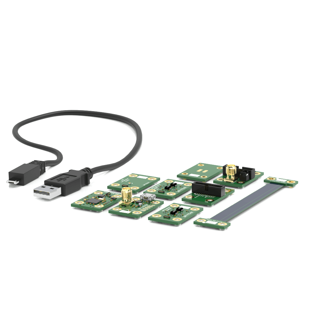 A USB to micro USB cable and multiple green circuit boards with various electronic components are arranged on a white surface.