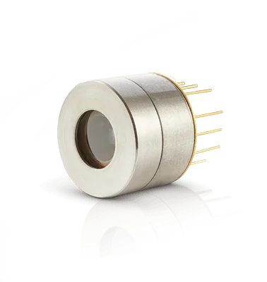 A cylindrical infrared detector with a metallic body and multiple gold pins on one side. It has a central lens-like feature and is resting on a reflective surface, casting a partial reflection.