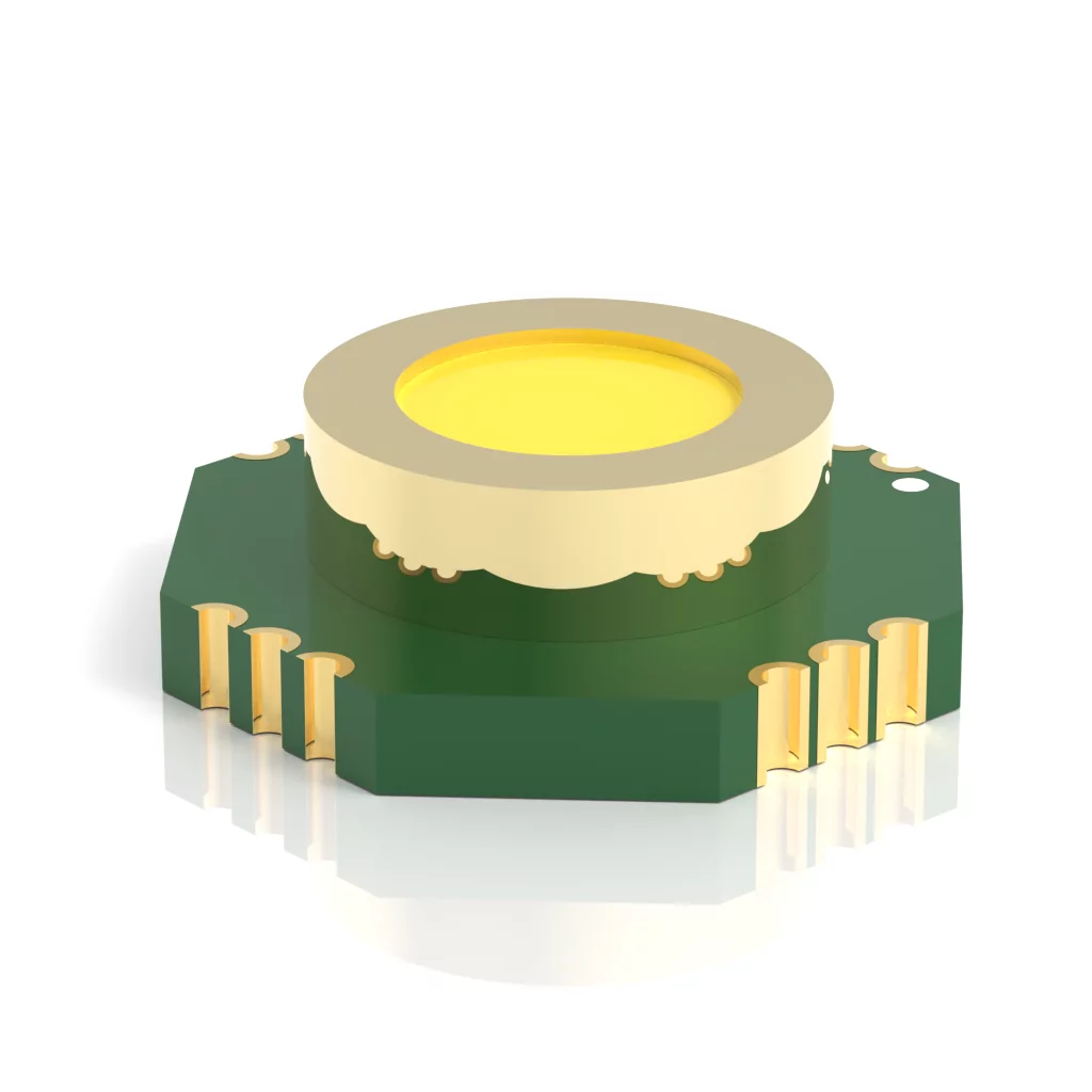 Close-up of a circular LED component with a yellow lens, set on a green base with gold connectors. The component is reflected on a white surface, showcasing its detailed structure and design.